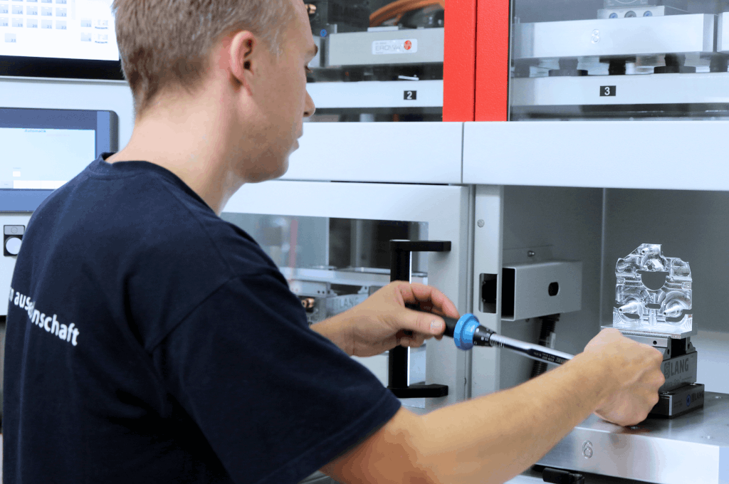 Männlicher Mitarbeiter montiert Baugruppe
